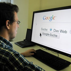 Eine Person vor dem Computer mit stark vergrösserter Webseite von Google.